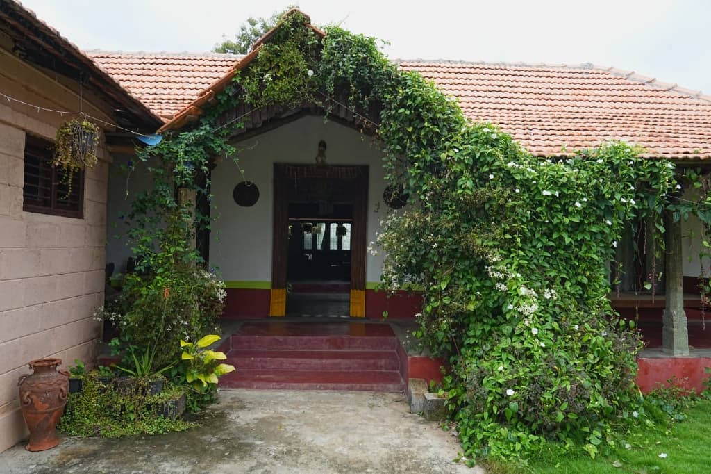 Traditional vintage house entrance with lush green floral arch at Shree Adventure