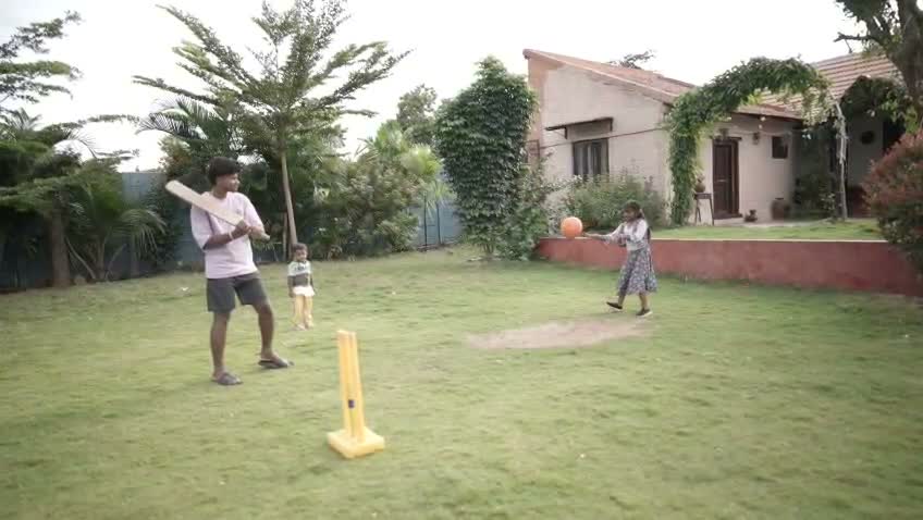 Family and guests playing lawn cricket matches on the green lawns